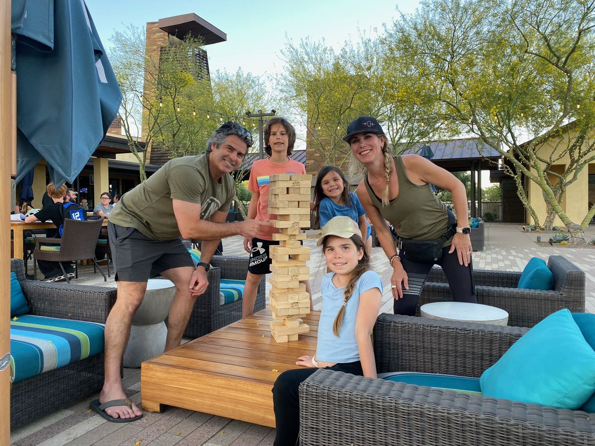 Family playing giant Jenga on patio