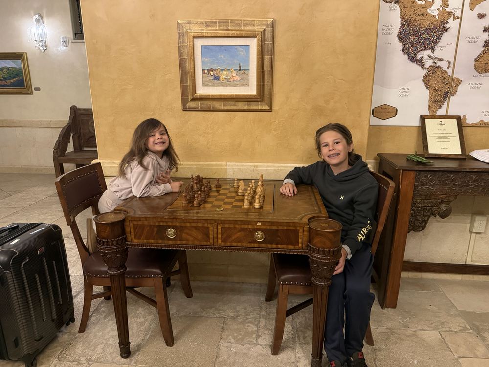 Kids playing chess in the Allegretto lobby