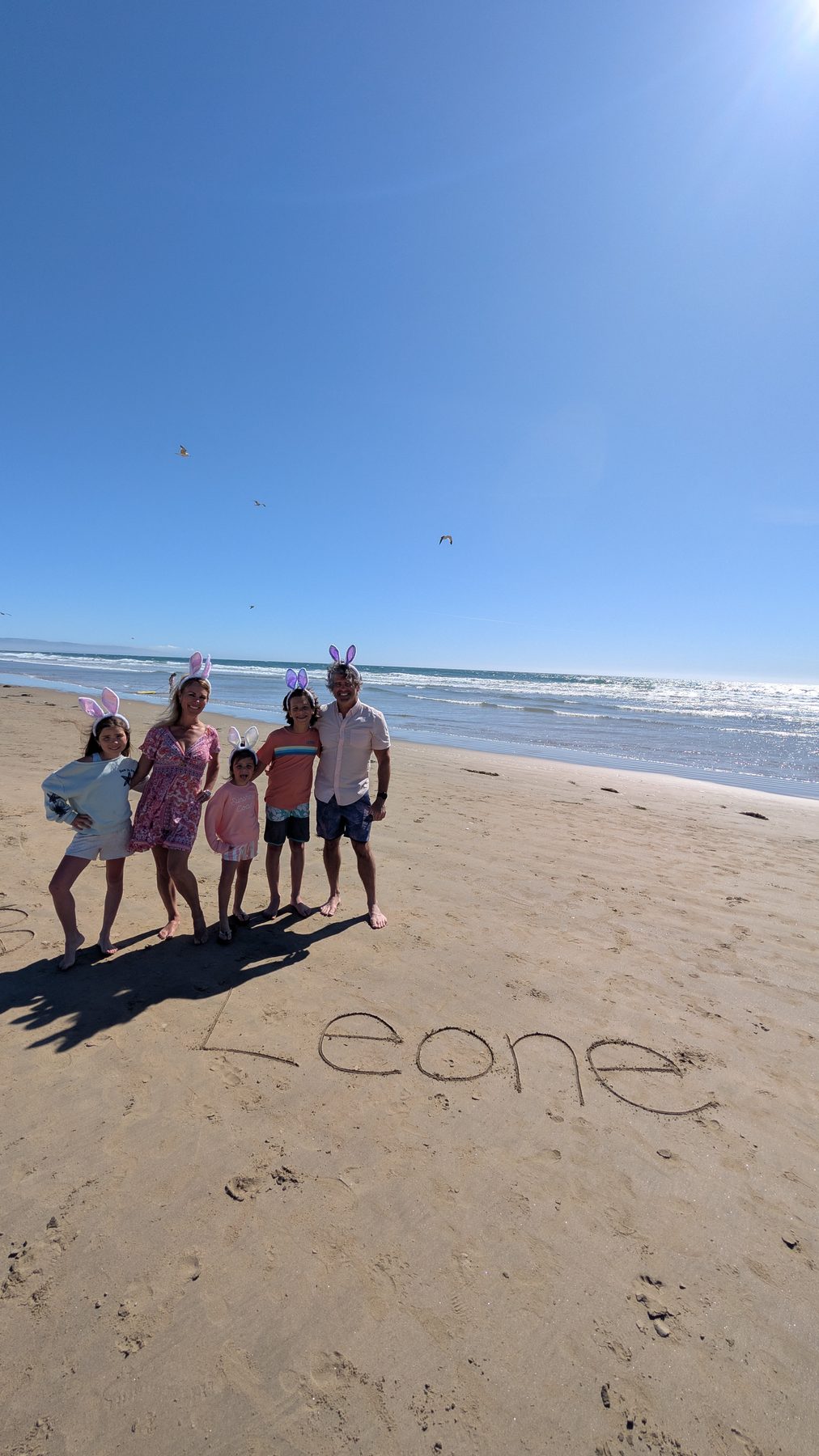 Leone family in Easter bunny ears with Leone written in the sand