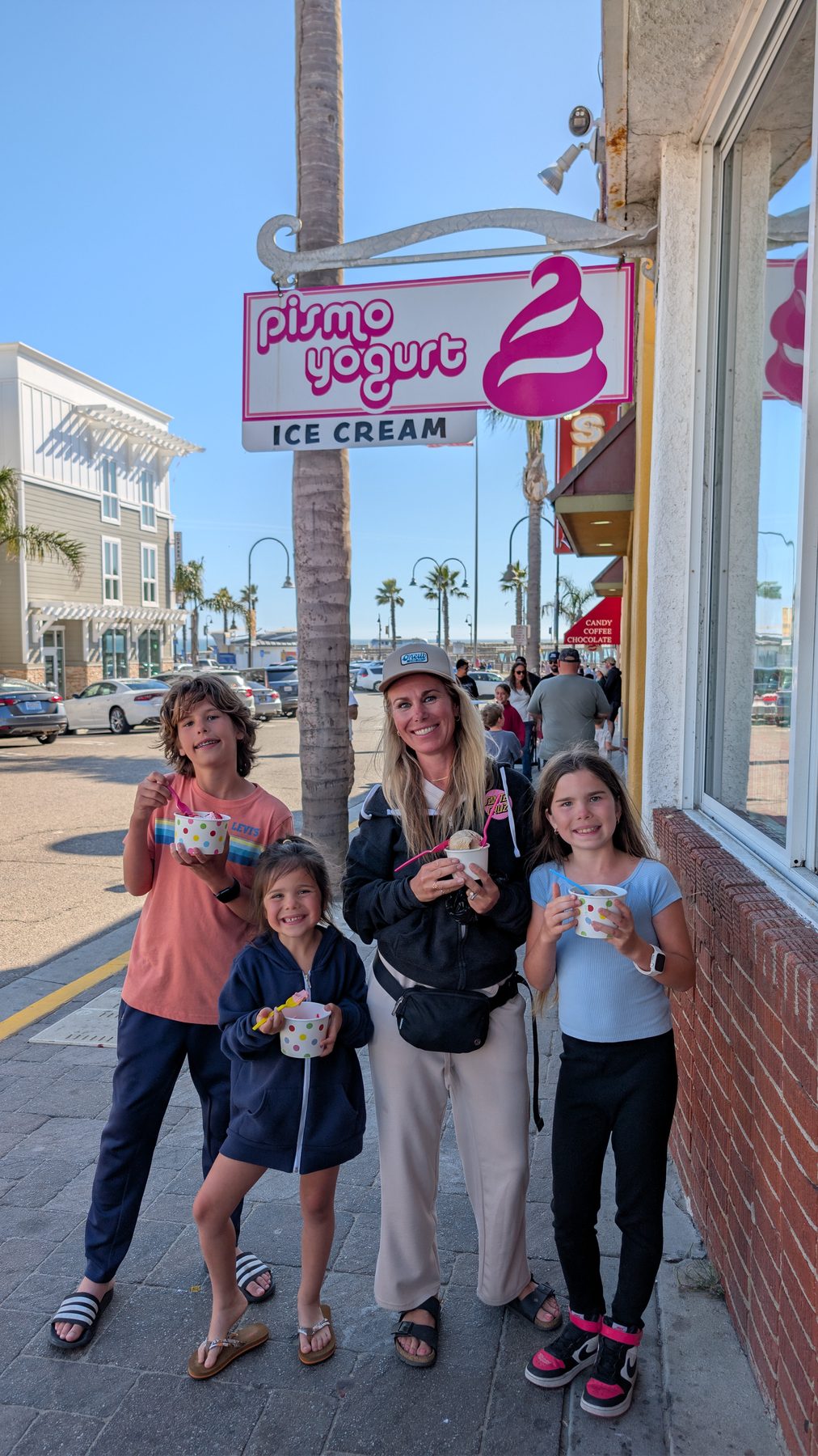 Family with ice cream cups outside Pismo Yogurt Ice Cream shop