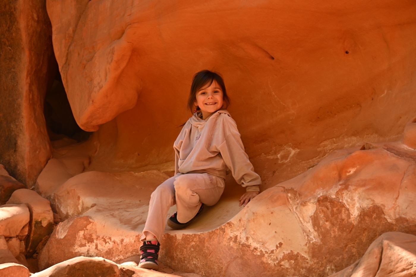 Kid sitting in red rock alcove