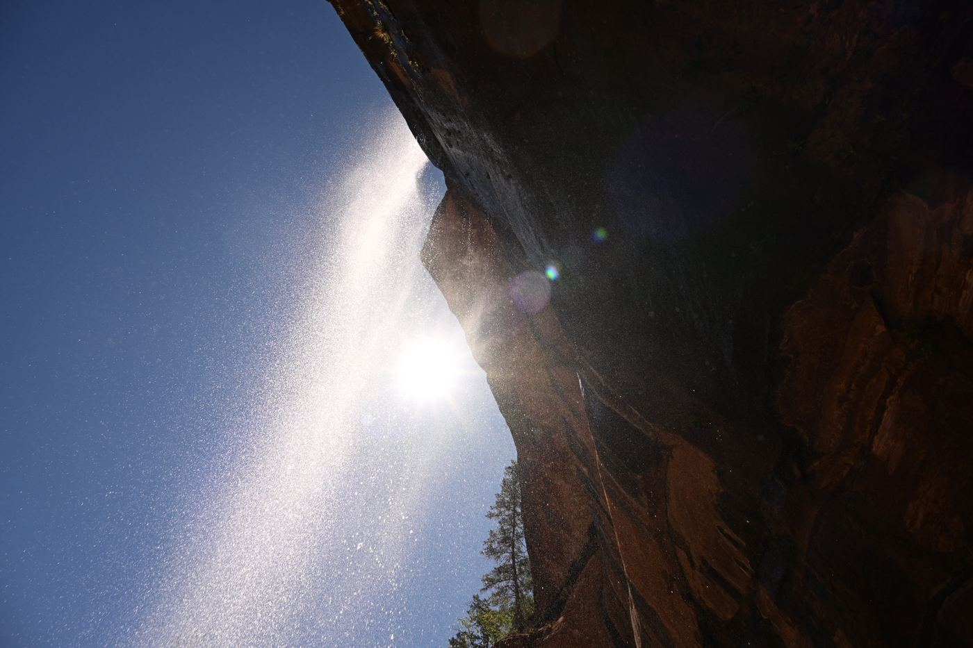 Waterfall mist with sun flare over canyon