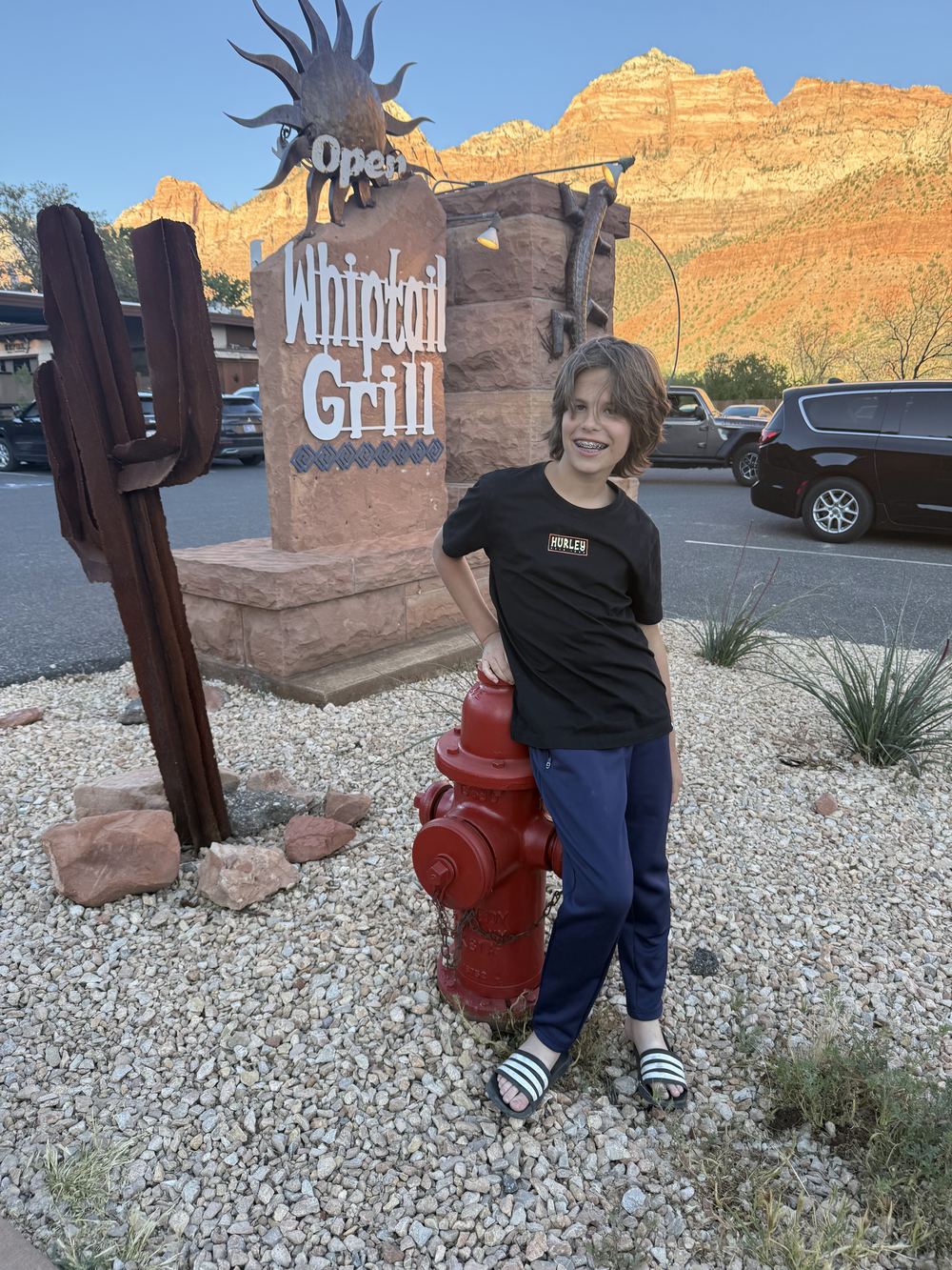 Son at Whiptail Grill sign at golden hour