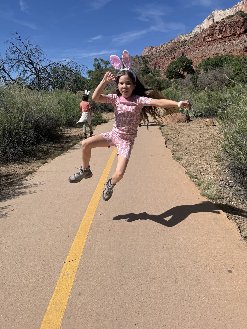 Perrisi leaping on trail in Easter bunny ears