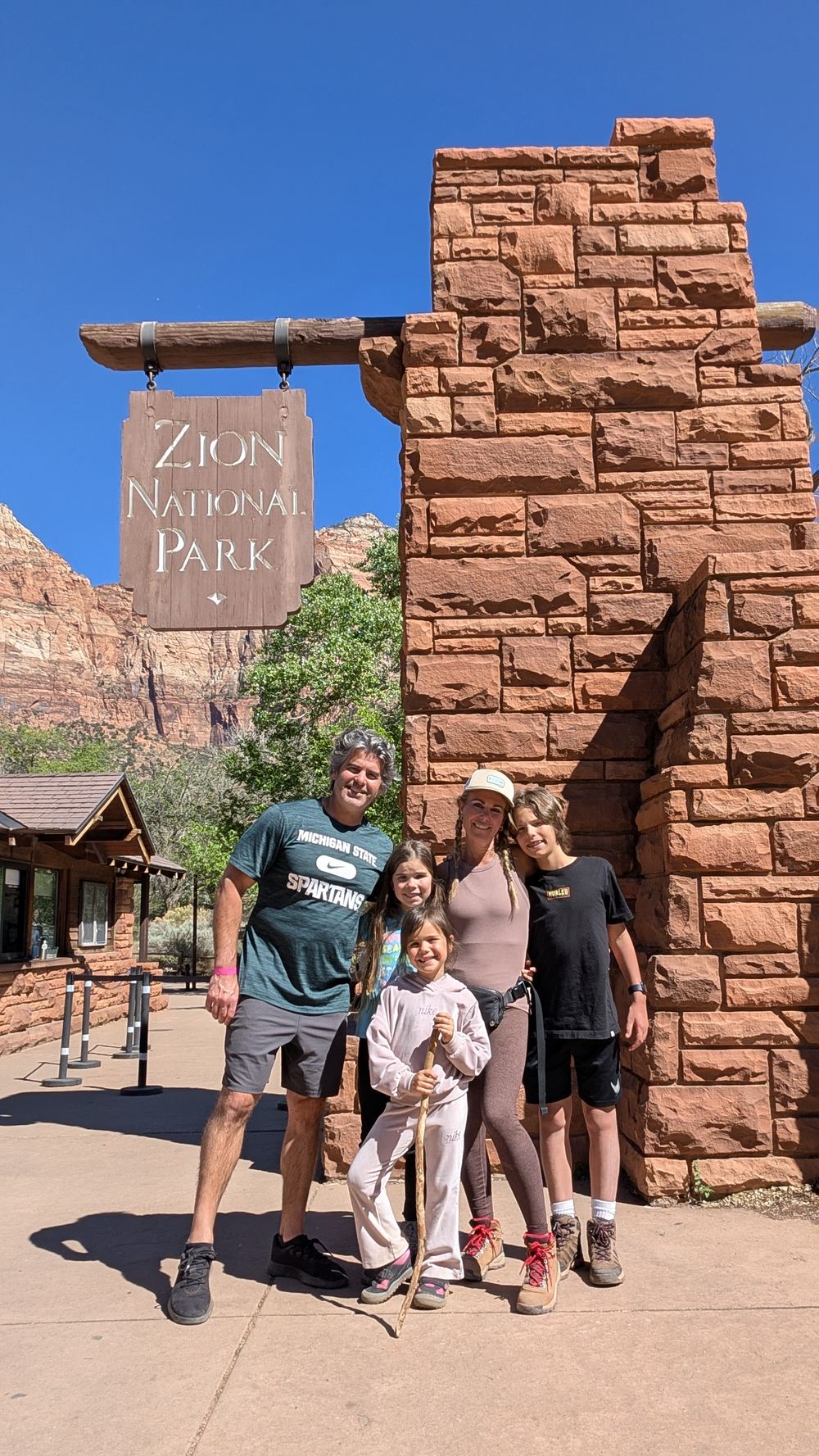 Family at the Zion National Park entrance sign